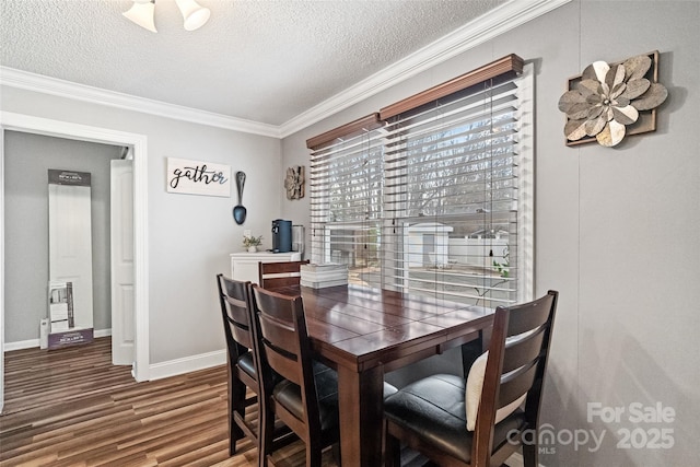 dining space featuring crown molding, baseboards, a textured ceiling, and wood finished floors