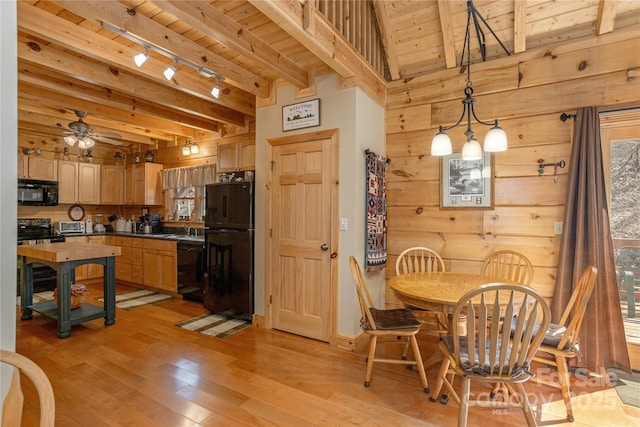 dining area with rail lighting, wooden walls, beamed ceiling, light wood finished floors, and wood ceiling