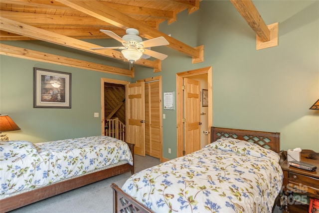 bedroom featuring beamed ceiling, ceiling fan, carpet flooring, and a closet