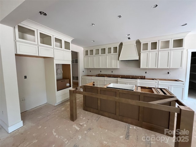 1204 Sage Pine Cir, Clover, SC 29710 - kitchen featuring premium range hood, white cabinets, a kitchen island, and glass insert cabinets