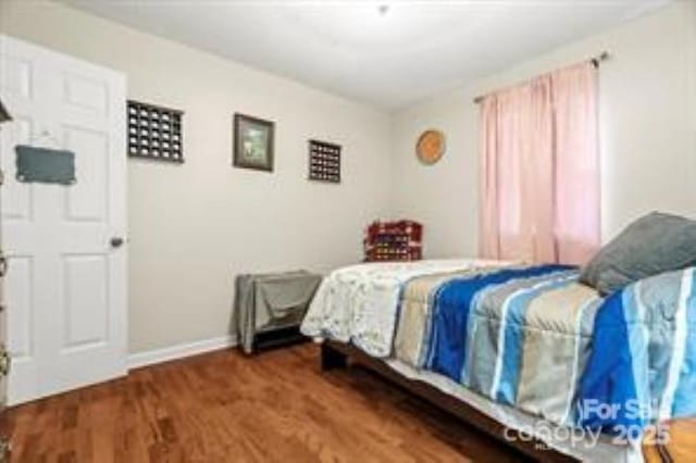 bedroom with baseboards and wood finished floors