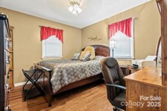 bedroom with baseboards, ceiling fan, and wood finished floors