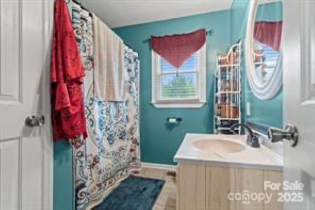full bathroom with baseboards, curtained shower, tile patterned flooring, and vanity