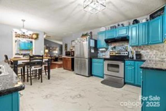 kitchen featuring a notable chandelier, under cabinet range hood, appliances with stainless steel finishes, and blue cabinetry