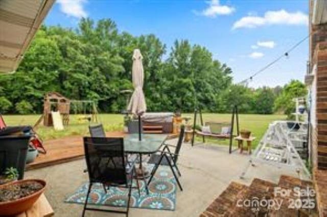 view of patio featuring a playground and outdoor dining space