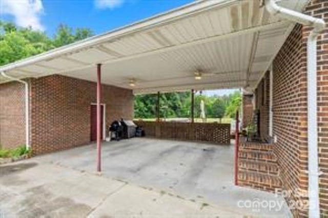 view of parking with an attached carport and ceiling fan