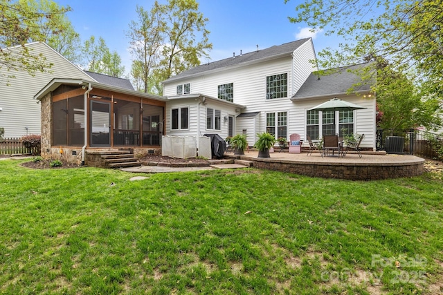 back of house featuring a lawn, a sunroom, fence, and a patio area