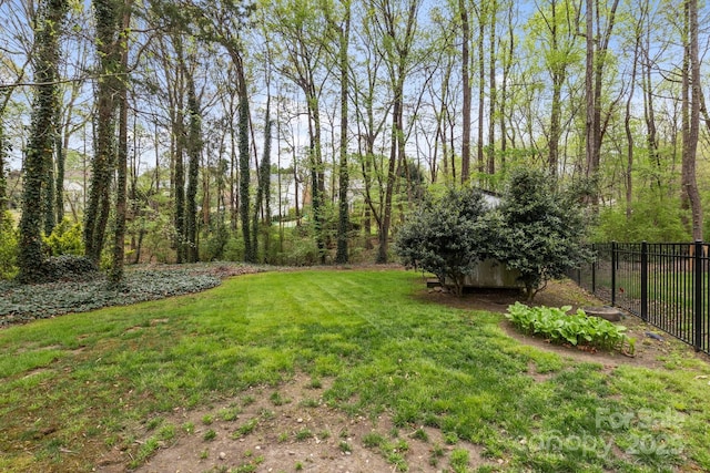 view of yard featuring fence, a storage shed, and an outdoor structure