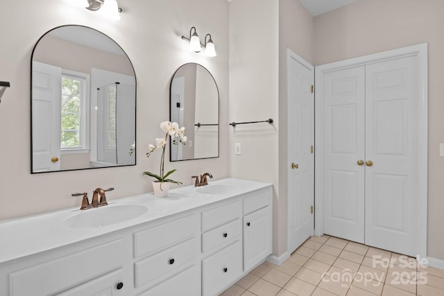 bathroom featuring double vanity, a closet, a sink, and tile patterned floors