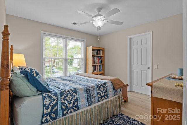 bedroom with ceiling fan, visible vents, and light wood finished floors
