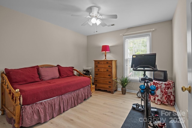 bedroom with baseboards, visible vents, ceiling fan, and wood finished floors