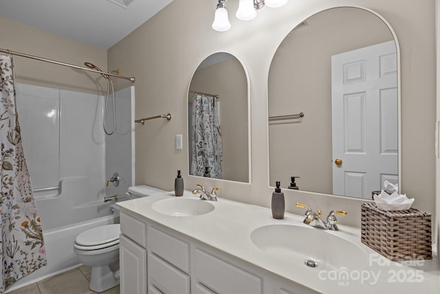 bathroom featuring double vanity, a sink, toilet, and tile patterned floors