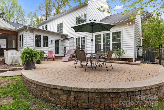 rear view of house featuring a patio, a shingled roof, fence, and cooling unit