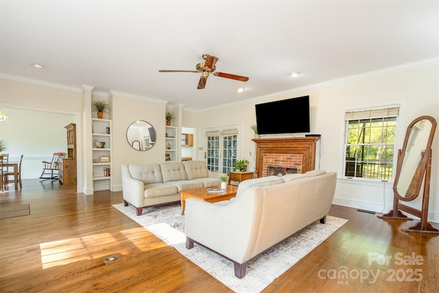 119 Lakenheath Ln, Matthews, NC 28105 - living room featuring a brick fireplace, a ceiling fan, ornamental molding, and wood finished floors