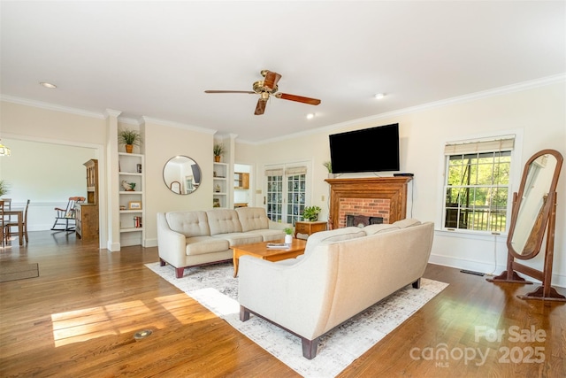 119 Lakenheath Ln, Matthews, NC 28105 - living room featuring a fireplace, a ceiling fan, ornamental molding, and wood finished floors