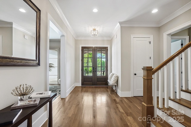 entrance foyer with ornamental molding, baseboards, stairs, and wood finished floors