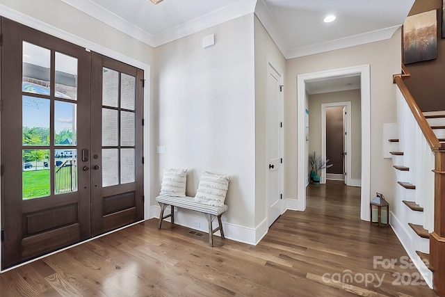 foyer entrance with stairs, wood finished floors, french doors, and crown molding