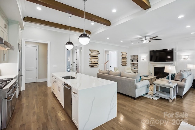 kitchen with white cabinets, ceiling fan, beam ceiling, appliances with stainless steel finishes, and a sink