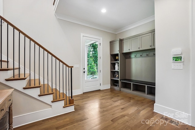 mudroom with baseboards, visible vents, ornamental molding, and wood finished floors