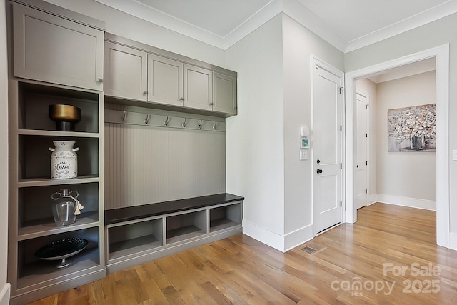 mudroom featuring baseboards, light wood-style floors, and crown molding