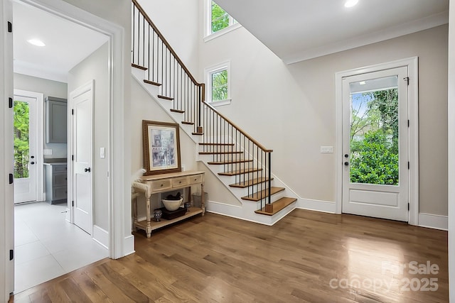 foyer with a wealth of natural light, stairway, and wood finished floors