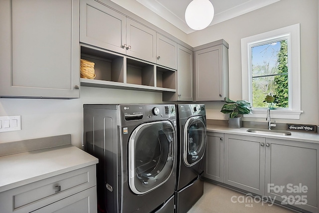 laundry area featuring independent washer and dryer, a sink, and cabinet space