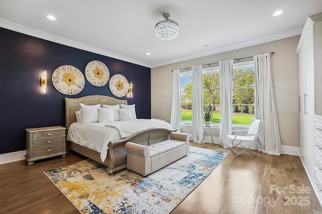 bedroom featuring baseboards, an accent wall, recessed lighting, and dark wood finished floors