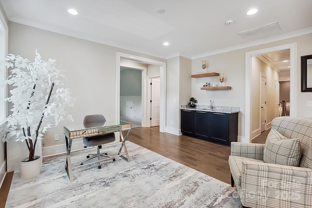 office space with recessed lighting, wet bar, a sink, visible vents, and wood finished floors