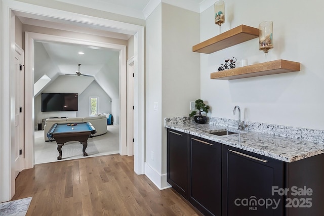 bar featuring ceiling fan, wood finished floors, a sink, billiards, and indoor wet bar