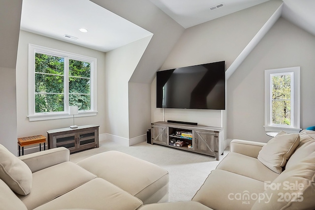 living area featuring plenty of natural light, light colored carpet, and visible vents