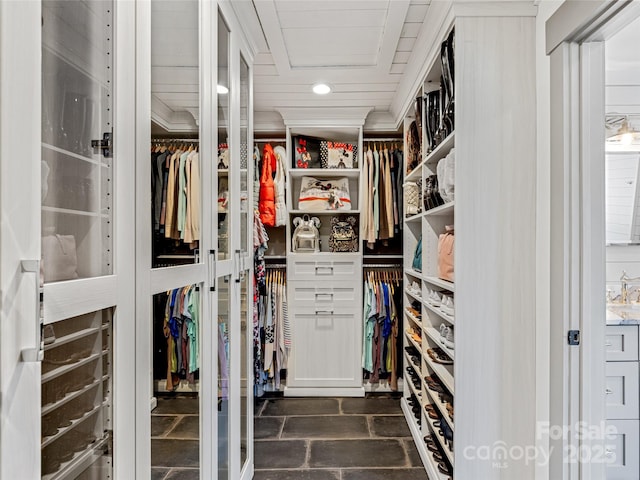 spacious closet featuring stone tile floors