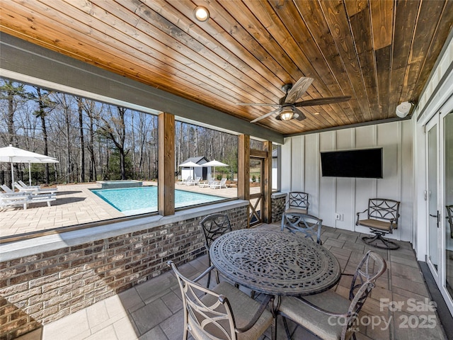 pool featuring ceiling fan, a patio area, and outdoor dining space