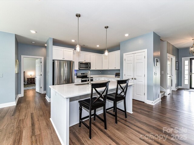 3012 Ocean Dr, Monroe, NC 28110 - kitchen with dark wood finished floors, white cabinetry, light countertops, and appliances with stainless steel finishes