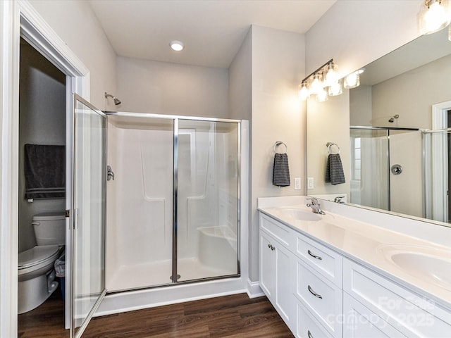 3012 Ocean Dr, Monroe, NC 28110 - bathroom with a shower stall, double vanity, toilet, wood finished floors, and a sink
