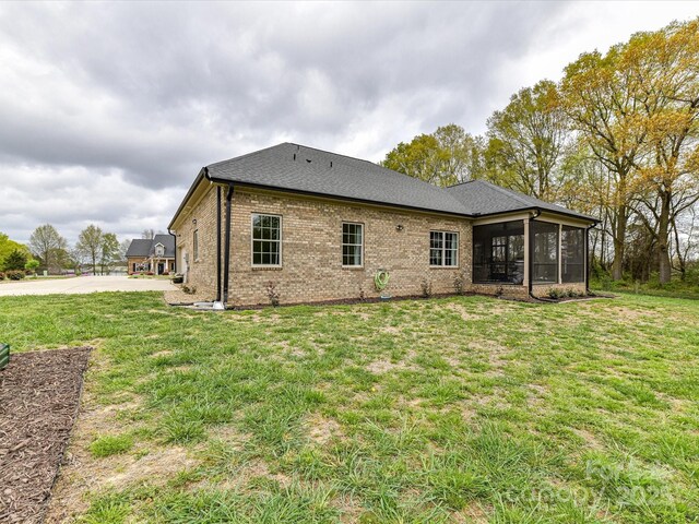 3012 Ocean Dr, Monroe, NC 28110 - rear view of house featuring a sunroom, brick siding, and a yard