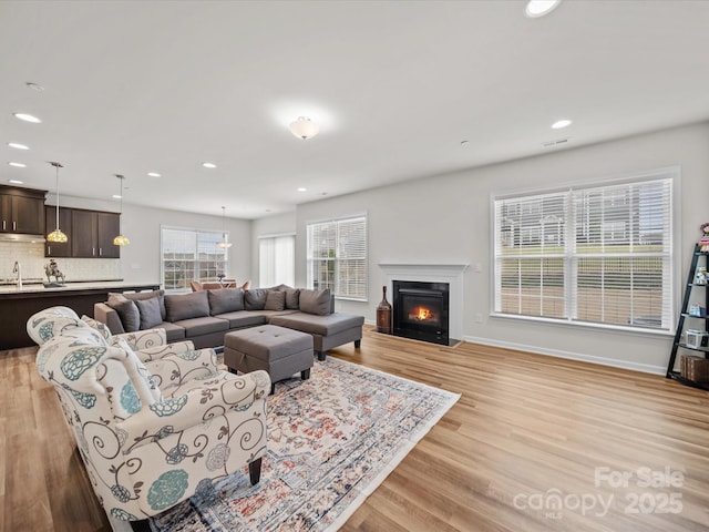 9582 Creighton Rd NW, Concord, NC 28027 - living room with light wood-style flooring, a fireplace with flush hearth, and recessed lighting