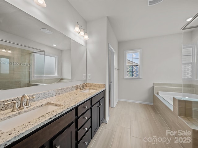 9582 Creighton Rd NW, Concord, NC 28027 - bathroom featuring double vanity, a sink, baseboards, and a bath