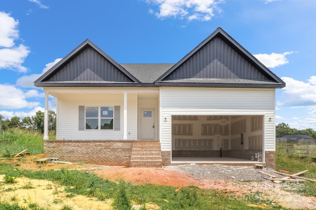 2508 Rock Dam Rd, Lincolnton, NC 28092 - view of front of house with board and batten siding, brick siding, a garage, covered porch, and gravel driveway