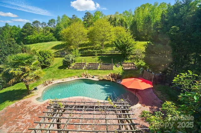 outdoor pool with a yard and fence