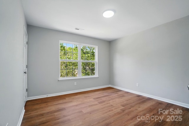 unfurnished room featuring baseboards and wood finished floors