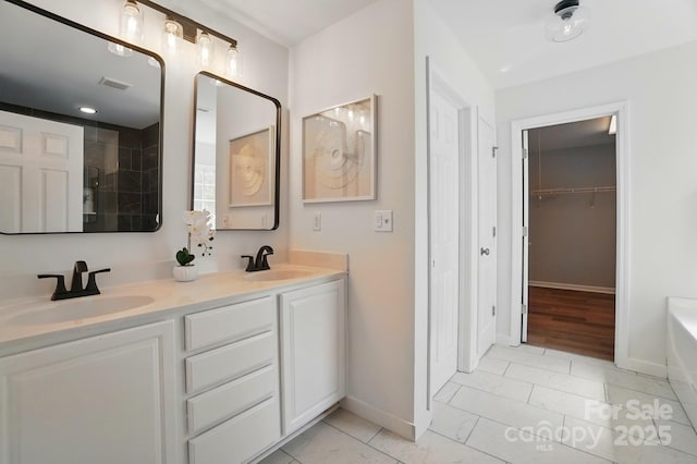 bathroom featuring a sink, visible vents, baseboards, and a bathing tub