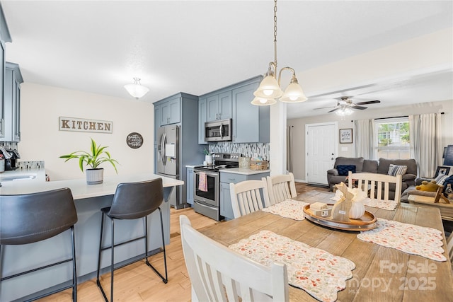 dining space featuring ceiling fan and light wood-style floors