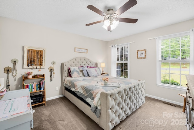 bedroom with baseboards, carpet floors, visible vents, and a ceiling fan