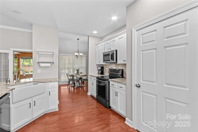 4159 Isle Of Pines Dr, Denver, NC 28037 - kitchen with appliances with stainless steel finishes, a sink, a chandelier, decorative backsplash, and white cabinetry