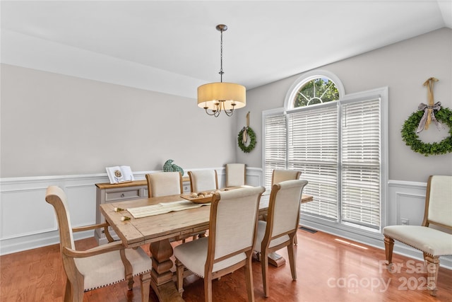 4159 Isle Of Pines Dr, Denver, NC 28037 - dining area with light wood finished floors, a chandelier, a wainscoted wall, and a decorative wall