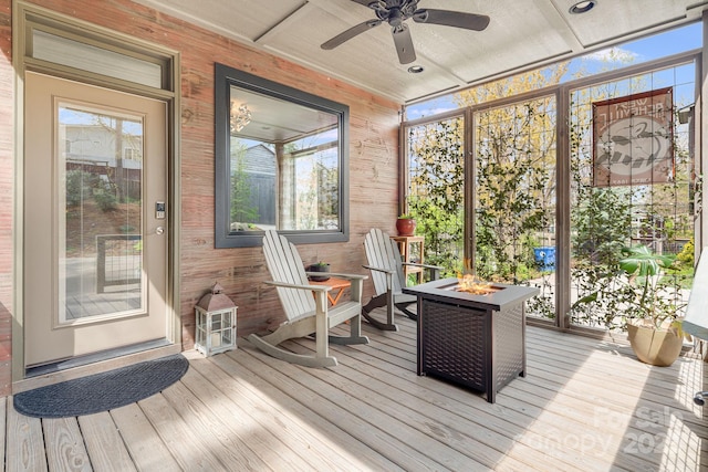 sunroom with a ceiling fan, an outdoor fire pit, and a healthy amount of sunlight