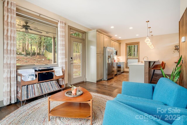 living room with baseboards, a ceiling fan, plenty of natural light, and recessed lighting
