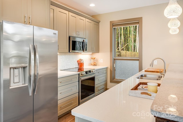 kitchen featuring stainless steel appliances, light countertops, a sink, and decorative backsplash