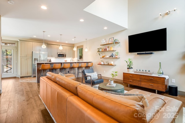 living room featuring light wood-type flooring, baseboards, and recessed lighting