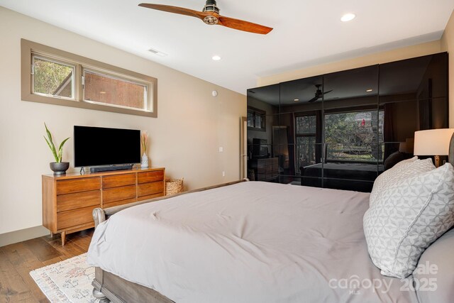 bedroom with recessed lighting, visible vents, baseboards, and wood finished floors